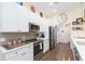 Modern kitchen with white cabinets, stainless steel appliances and wood flooring at 10328 Henderson St, Spring Hill, FL 34608