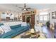 Living room with teal sofa, hardwood floors, and view of kitchen at 10328 Henderson St, Spring Hill, FL 34608