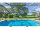 Refreshing blue pool with a screened enclosure, perfect for summer enjoyment at 10328 Henderson St, Spring Hill, FL 34608