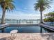 Empty swimming pool with palm trees and waterfront view at 16124 4Th E St, Redington Beach, FL 33708