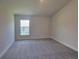 Bright bedroom with carpeted floors and large window at 36141 Welsh Glade Rd, Dade City, FL 33525