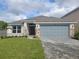 One-story house with gray siding, stone accents, and a two-car garage at 36141 Welsh Glade Rd, Dade City, FL 33525