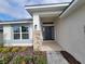 House entrance with stone accents and a dark gray door at 36141 Welsh Glade Rd, Dade City, FL 33525