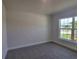 Spacious bedroom with plush carpeting and large window offering ample natural light at 36179 Welsh Glade Rd, Dade City, FL 33525