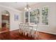 White dining set in bright dining room with hardwood floors and large windows at 5203 Friar Tuck Ct, Tampa, FL 33647