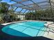 An inviting in-ground pool features a screened enclosure and surrounded by lush greenery, perfect for relaxation at 601 42Nd Ne Ave, St Petersburg, FL 33703