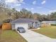 Gray house with a fenced yard, driveway, and car at 6103 Fairway Dr, Ridge Manor, FL 33523