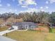 Gray house with a fenced yard, driveway, and car at 6103 Fairway Dr, Ridge Manor, FL 33523