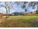 Large backyard with wooden fence, fire pit, and plenty of grassy space at 6103 Fairway Dr, Ridge Manor, FL 33523