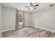 Spacious bedroom with wood-look floors, ceiling fan, and a window with backyard view at 6103 Fairway Dr, Ridge Manor, FL 33523