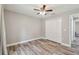 Well-lit bedroom with wood-look floors, double-door closet, and ceiling fan at 6103 Fairway Dr, Ridge Manor, FL 33523