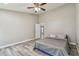 Bright bedroom with ceiling fan, wood-look floors, and access to other rooms at 6103 Fairway Dr, Ridge Manor, FL 33523