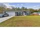Gray house with white garage door, and green lawn at 6103 Fairway Dr, Ridge Manor, FL 33523
