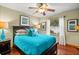 Bright bedroom featuring a ceiling fan and hardwood floors at 800 Weathersfield Dr, Dunedin, FL 34698