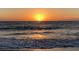 Orange sunset over the ocean waves at 100 Bluff View Dr # 415A, Belleair Bluffs, FL 33770