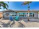 Gray house with waterfront view and blue chairs at 16101 6Th E St, Redington Beach, FL 33708