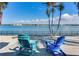 Relaxing waterfront view with two chairs, palm trees, and peaceful water at 16101 6Th E St, Redington Beach, FL 33708