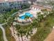 Aerial view of the community pool surrounded by white picket fences and lush tropical palm trees at 273 Madeira Cir, Tierra Verde, FL 33715