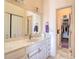 Bright bathroom featuring marble countertops, white cabinets, and a walk-in closet at 273 Madeira Cir, Tierra Verde, FL 33715