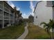 Well-maintained courtyard with palm trees, lush lawns, and a sidewalk at 273 Madeira Cir, Tierra Verde, FL 33715
