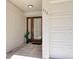 A brown paneled front door with sidelights is complemented by a ceramic tile entry and a sideload garage at 273 Madeira Cir, Tierra Verde, FL 33715