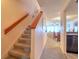 Hallway with carpeted stairs leads to living area with dining set and view at 273 Madeira Cir, Tierra Verde, FL 33715