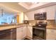 Modern kitchen with stainless appliances, stone countertops, and view to dining area at 273 Madeira Cir, Tierra Verde, FL 33715