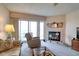 Bright living room showcasing a comfortable recliner, fireplace, ceiling fan, and glass sliding doors to an outdoor space at 273 Madeira Cir, Tierra Verde, FL 33715