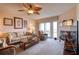 Comfortable living room features a cozy sofa, fireplace, ceiling fan, and sliding doors to access an outdoor space at 273 Madeira Cir, Tierra Verde, FL 33715