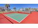 Community pickleball courts with red and green surfaces, surrounded by a fence and lush palm trees at 273 Madeira Cir, Tierra Verde, FL 33715