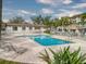 Community pool featuring a unique layout, a brick-lined patio, shaded tiki huts, and ample lounge seating at 273 Madeira Cir, Tierra Verde, FL 33715
