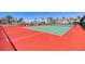 Community tennis courts with red and green surfaces, surrounded by a fence and lush palm trees at 273 Madeira Cir, Tierra Verde, FL 33715