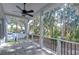 Covered back porch with a ceiling fan and wooded backyard view at 3125 Downing St, Clearwater, FL 33759