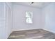 Bedroom with wood-look floors, white louvered doors, and a window at 3125 Downing St, Clearwater, FL 33759