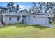 Newly constructed home with gray exterior, landscaping, and a two-car garage at 3125 Downing St, Clearwater, FL 33759