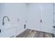 Laundry room with utility sink, white cabinets, and wood-look floors at 3125 Downing St, Clearwater, FL 33759