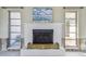 White brick fireplace with brass fire screen, centered beneath artwork at 380 Belle Point Dr, St Pete Beach, FL 33706