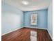 Light blue bedroom with wood floors and a window at 6213 Venezia Pl, Riverview, FL 33578