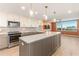 Modern kitchen with large island, stainless steel appliances, mosaic backsplash and an adjacent view from a large window at 736 Island Way # 606, Clearwater Beach, FL 33767