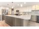 Modern kitchen with a mosaic backsplash, wine cooler, large island, stainless appliances, and pendant lighting at 736 Island Way # 606, Clearwater Beach, FL 33767