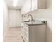 Well-organized laundry room with granite countertops, undermount sink, white cabinets and modern faucet at 736 Island Way # 606, Clearwater Beach, FL 33767