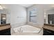 Spa-like bathroom featuring a corner soaking tub and dark wood cabinets at 9928 Ivory Dr, Ruskin, FL 33573