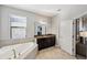 Elegant bathroom with soaking tub, granite vanity, and tiled shower at 9928 Ivory Dr, Ruskin, FL 33573