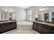 Luxurious bathroom with double vanity, soaking tub, and granite counters at 9928 Ivory Dr, Ruskin, FL 33573