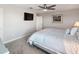 Bright bedroom featuring a ceiling fan, mounted TV, and plush carpeting at 9928 Ivory Dr, Ruskin, FL 33573