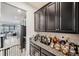 Home bar with granite countertop and dark cabinetry at 9928 Ivory Dr, Ruskin, FL 33573