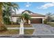 House exterior with a brick driveway and palm trees at 18052 Java Isle Dr, Tampa, FL 33647