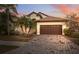 Beautiful home with a brown garage door and brick driveway at 18052 Java Isle Dr, Tampa, FL 33647