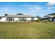 Home's backyard features a large grassy area and partial view of the house at 2407 Locksley St # 224, Sun City Center, FL 33573
