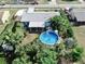 An aerial view of a cozy house with a beautiful above ground pool and a mature tree-lined backyard at 2575 Shenandoah St, North Port, FL 34287